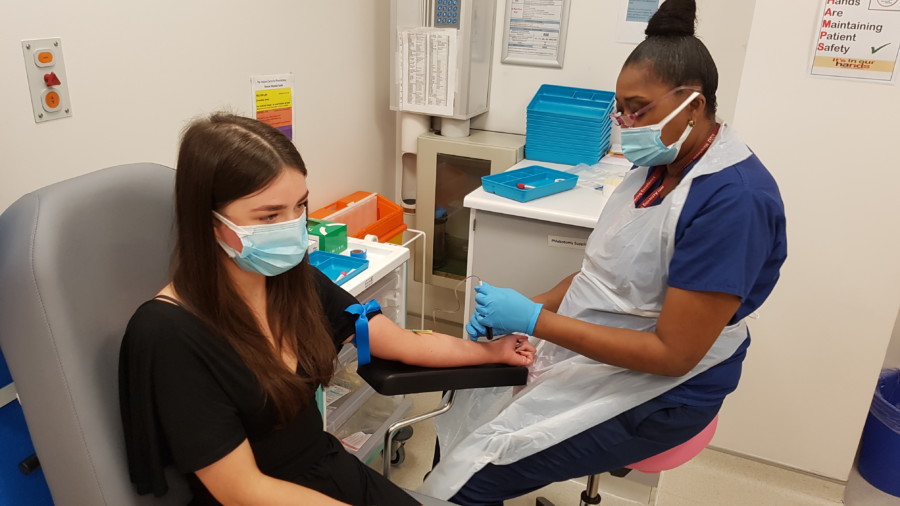 Image shows Sally having blood samples taken by Nursing Assistant Diane Sally giving blood samples, with Nursing Assistant Diane Bygrave-Fyffe.