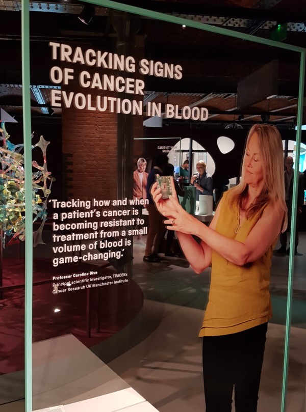 Image shows a Cancer Revolution exhibit display featuring Professor Caroline Dive