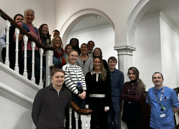 A group of people who are on the scheme standing on a staircase