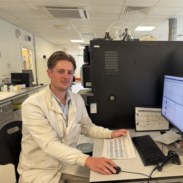 Man in lab coat at desk with computer